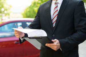 Close-up Of Male Holding Clipboard Near Car